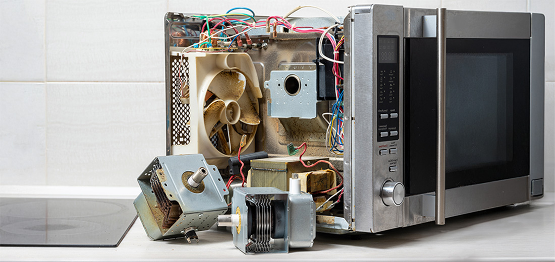 Disassembled microwave oven showing internal components and wiring.